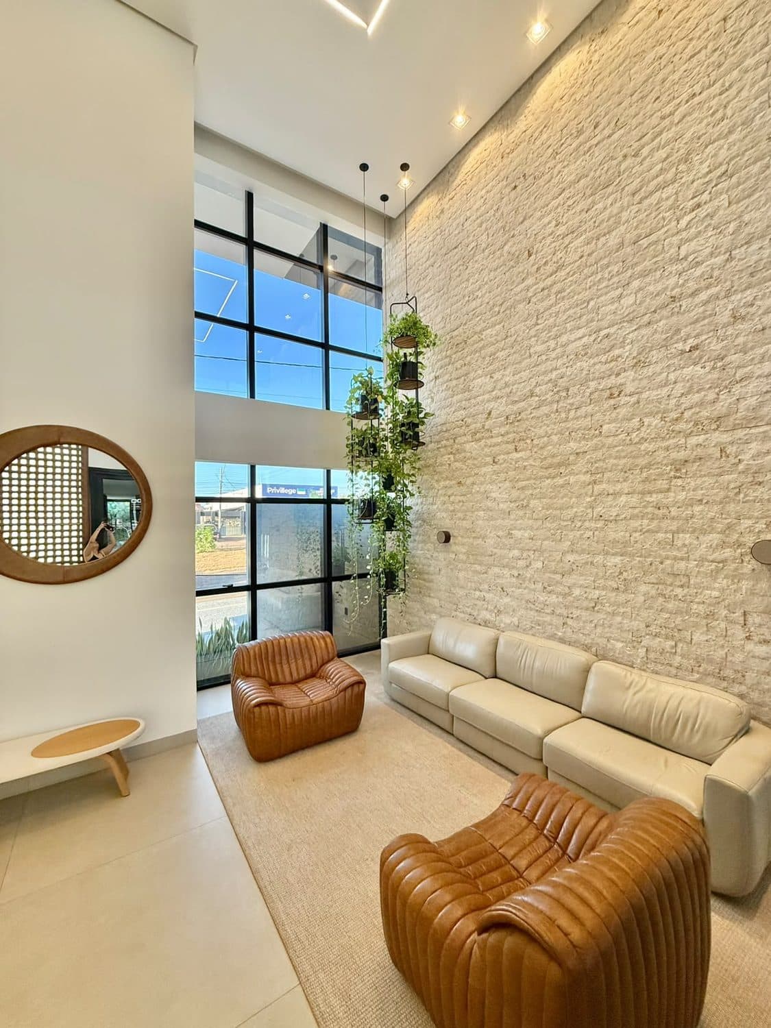 Sala de espera da sede, com sofás de couro e parede em pedra natural