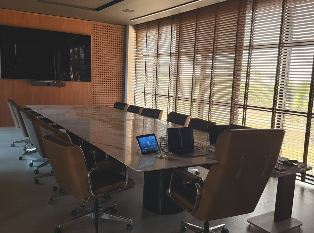 Sala de reunião da sede, com mesa ampla e acesso ao pátio interno